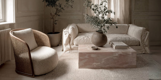 Modern onyx coffee table centerpiece with neutral sofa and textured rug in a bright living room.
