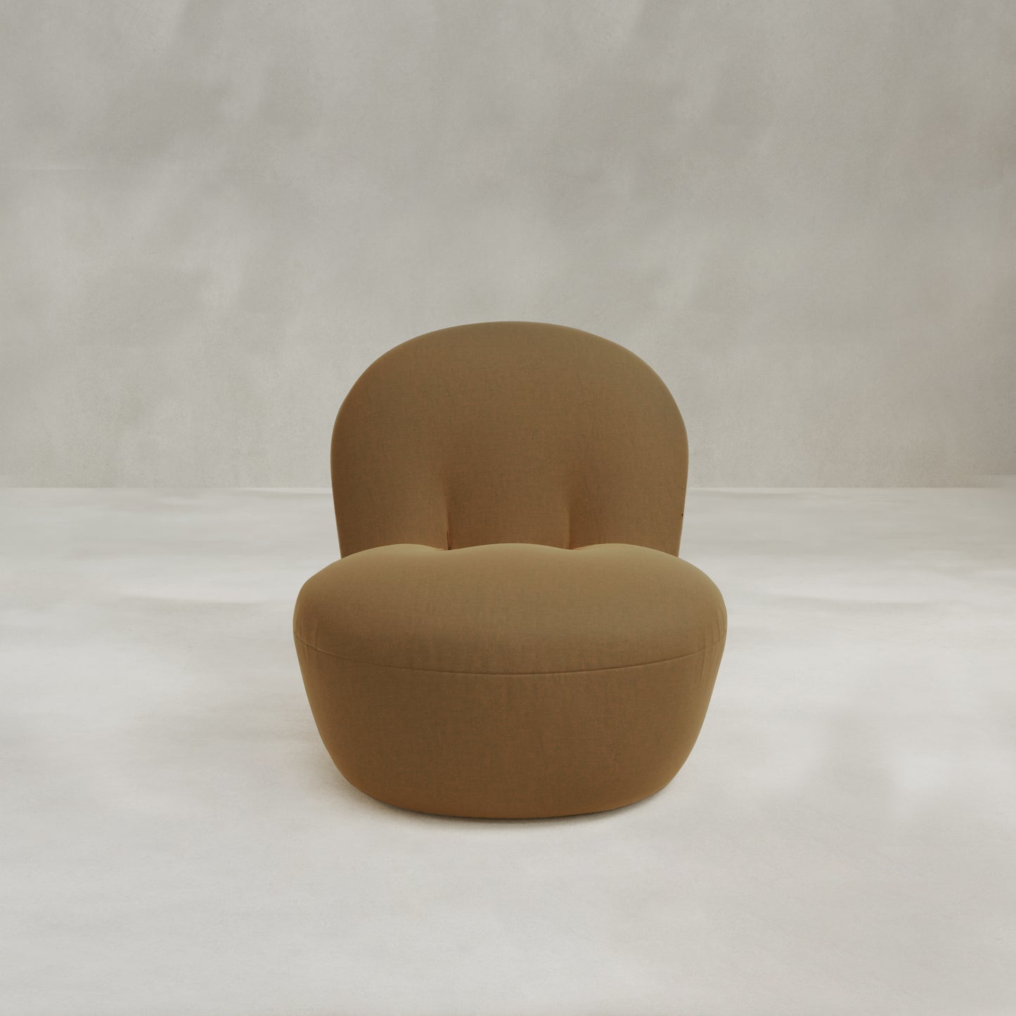 The Colette Chair is a modern, armless lounge chair with a rounded back and seat, upholstered in textured light brown fabric, shown against a plain, light-colored background.