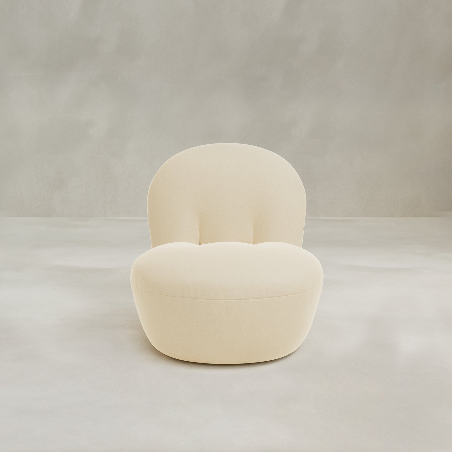 The Colette Chair is a modern cream-colored upholstered lounge chair featuring plush cushions and a rounded, tufted backrest and seat, shown against a light grey background for contemporary style.