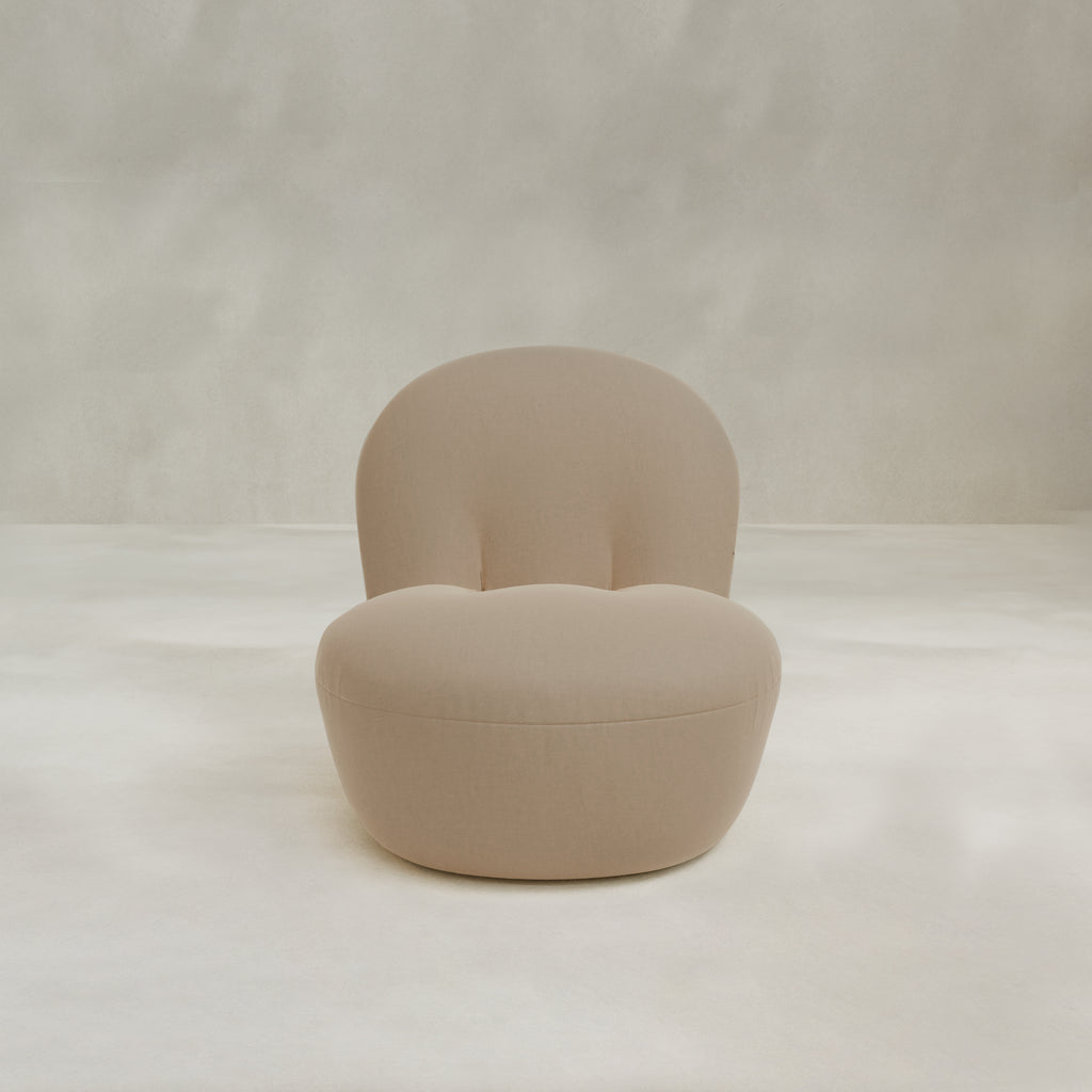 The Colette Chair is a modern beige upholstered lounge chair with plush cushions, rounded backrest and seat, shown on a light, minimal background.