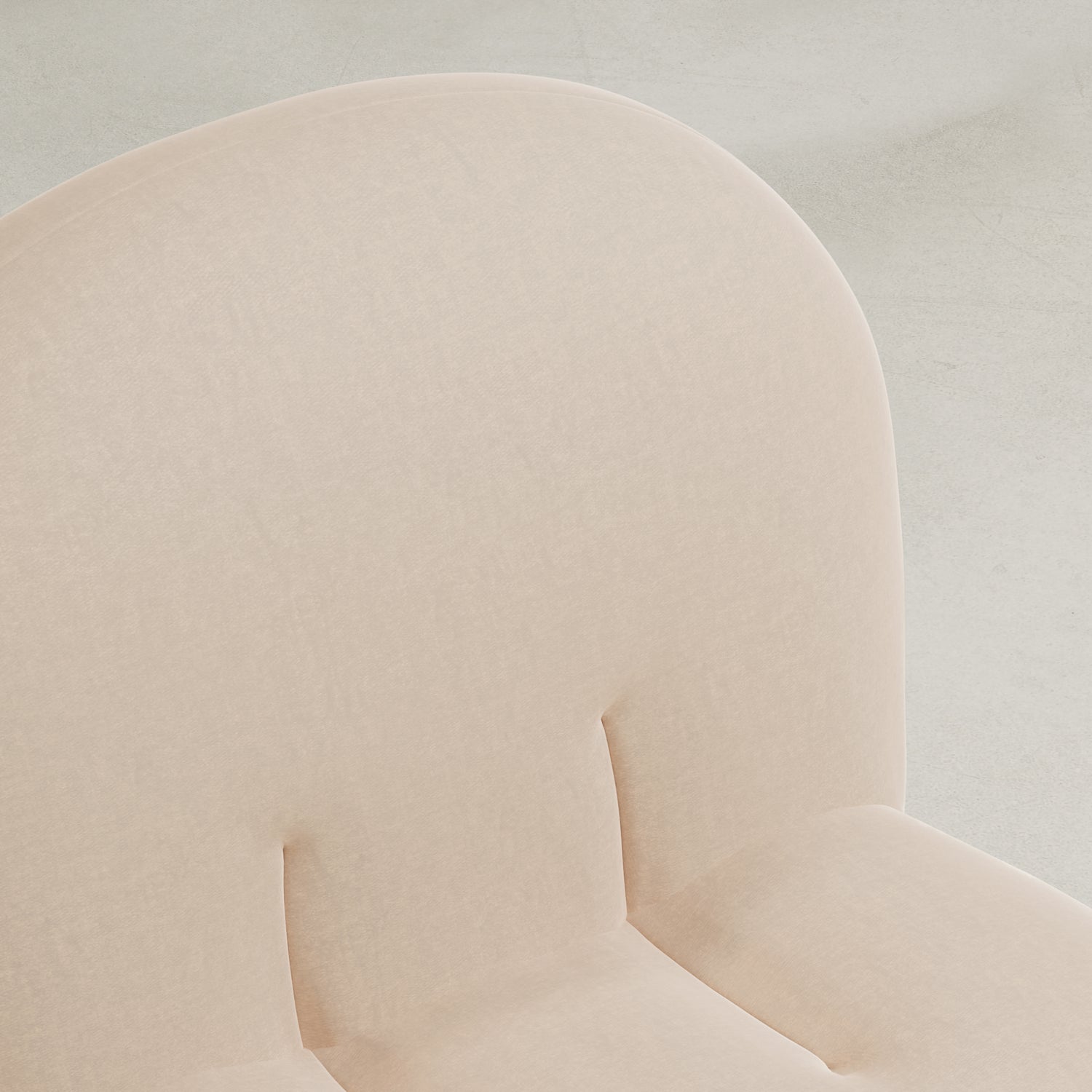 Close-up of the Colette Chair, featuring light beige upholstery, a rounded cushioned backrest with subtle tufting, and plush cushions that highlight its rich texture against a neutral background.