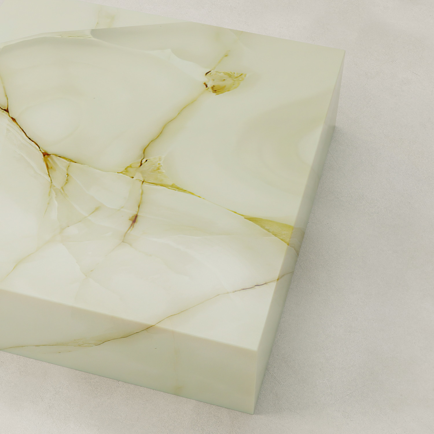 A close-up of the Blanchaire Onyx Coffee Table XL highlights its polished, cream-toned stone with delicate veining, luminous finish, smooth edges, and subtle gold accents atop a pale textured surface.