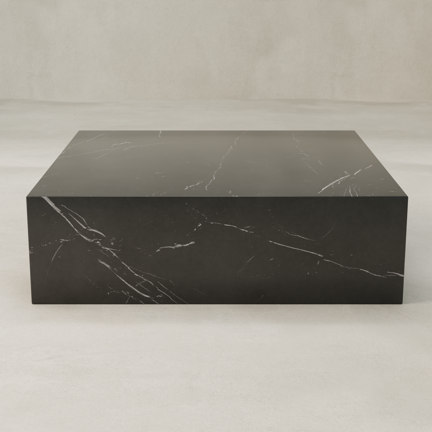 The Obscara Coffee Table XL, a rectangular black marble plinth with subtle white veining, exudes timeless sophistication on a light neutral floor against a plain pale wall.