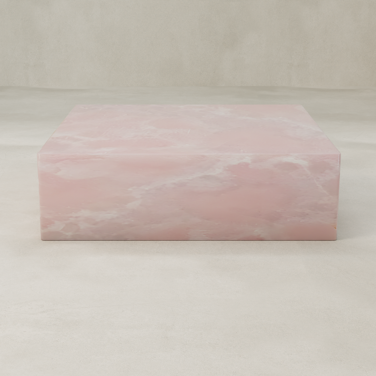 A square, pink onyx block rests on a light, textured surface with a neutral beige background, reflecting the elegance of the Cora Onyx Coffee Table XL.