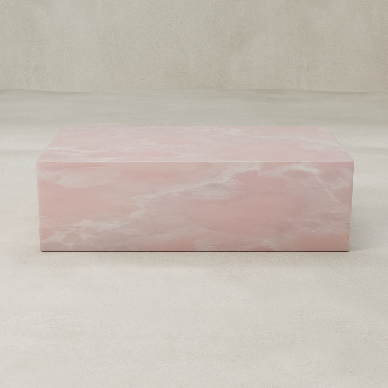 The Cora Onyx Coffee Table is a rectangular, solid piece with a smooth, polished surface featuring pink and white marbled patterns of pink onyx on a light beige background.