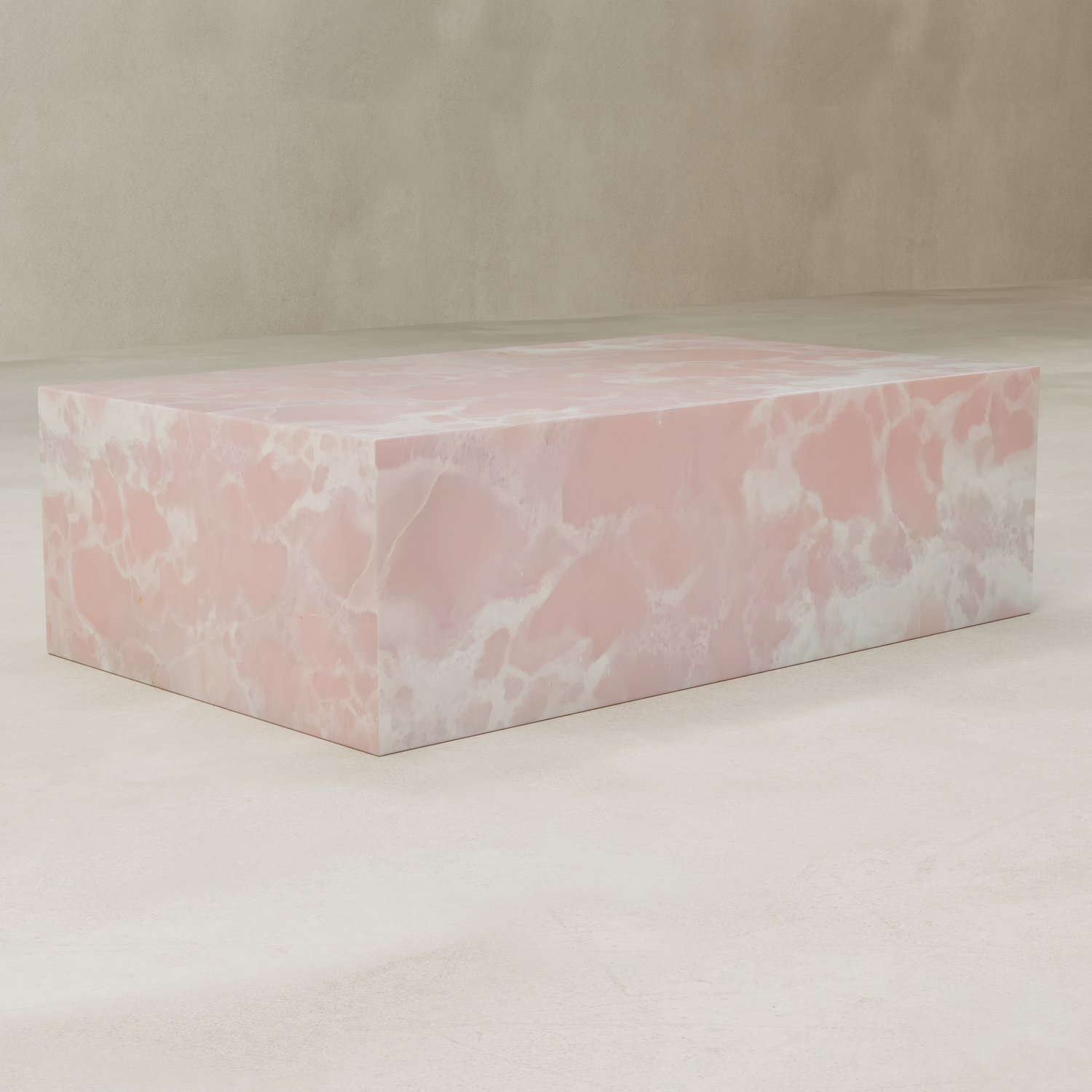 The Cora Onyx Coffee Table, featuring a smooth, glossy pink and white marble-like surface, stands on a light textured floor against a beige wall.