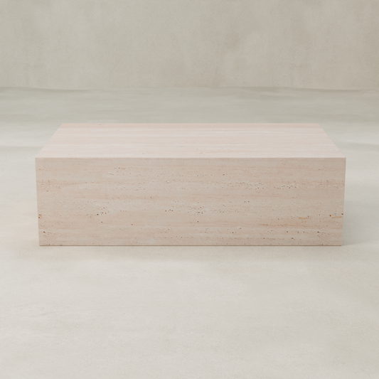 The Alessia Coffee Table is a rectangular, light beige travertine piece with a smooth surface and minimalist design, exuding timeless elegance and sculptural presence on a pale, seamless background.