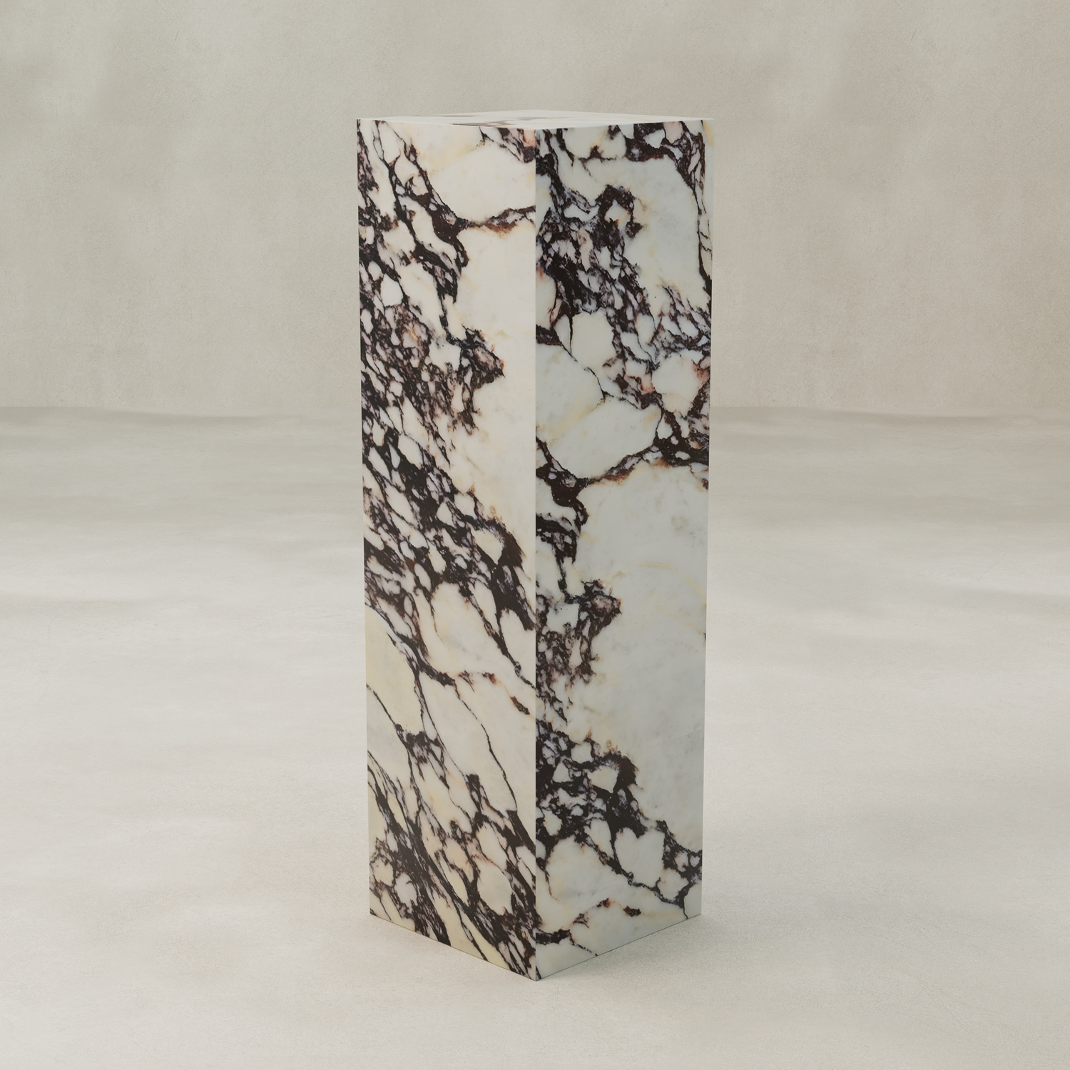 The Calacatta Tall Tower Plinth features a tall, rectangular form with a white base and striking dark brown marble veining, standing on a light, textured floor against a neutral background to highlight its luxurious hues.