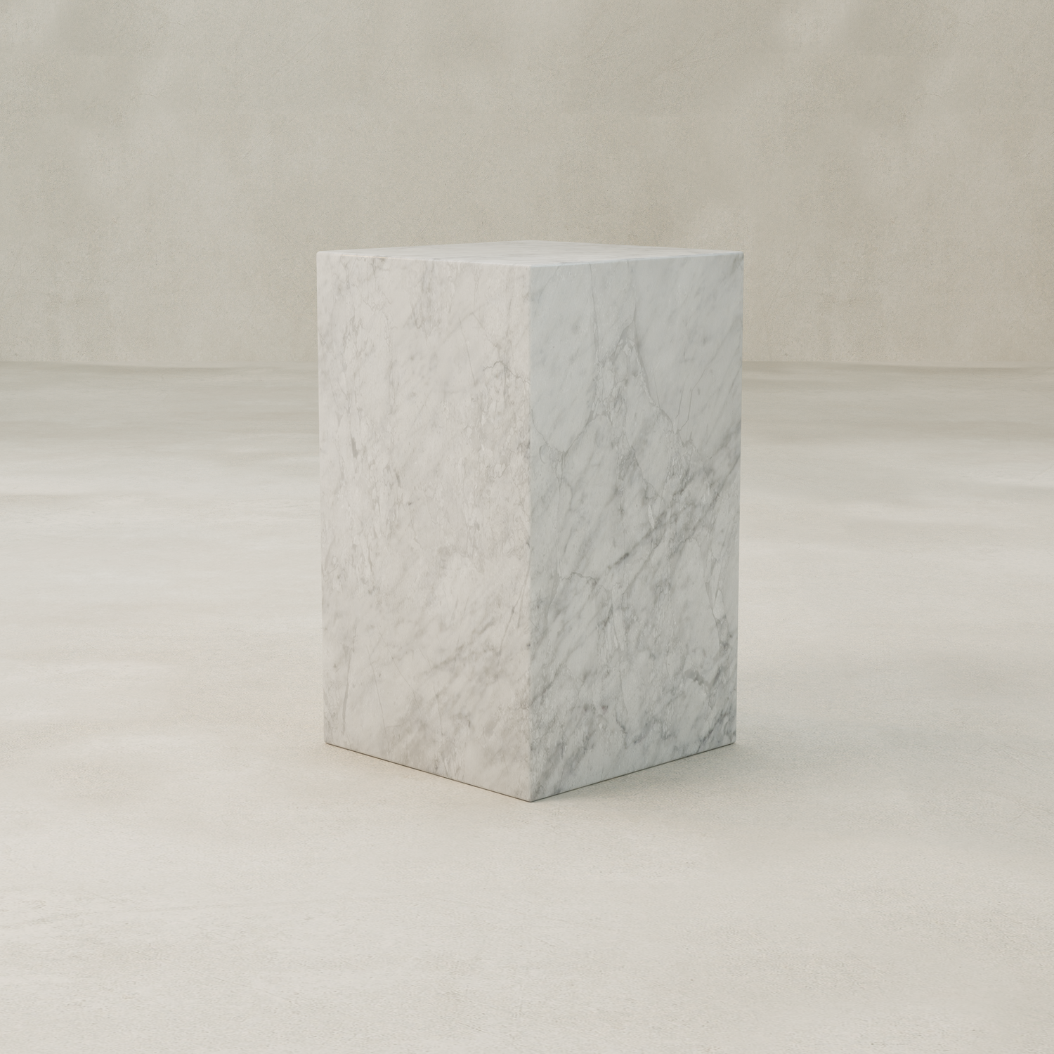 The Griselle Marble Plinth - Tall stands alone on a pale, textured surface with a neutral beige background. Its large, smooth cube features natural gray veining—ideal for adding elegance to any interior space.