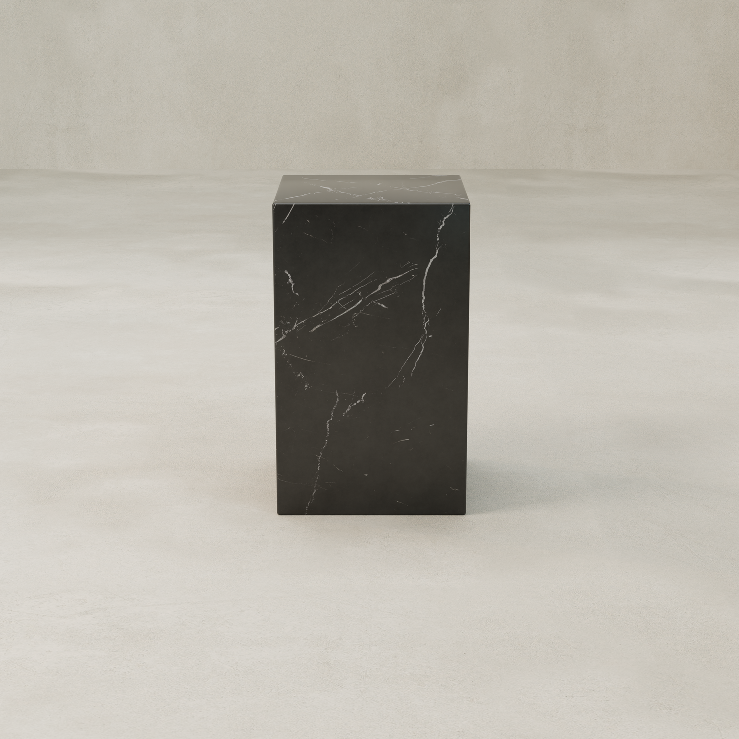 The Obscara Plinth - Tall, a tall rectangular black marble pedestal with subtle white veining, adds timeless sophistication as it stands on a smooth light beige surface against a matching neutral background.