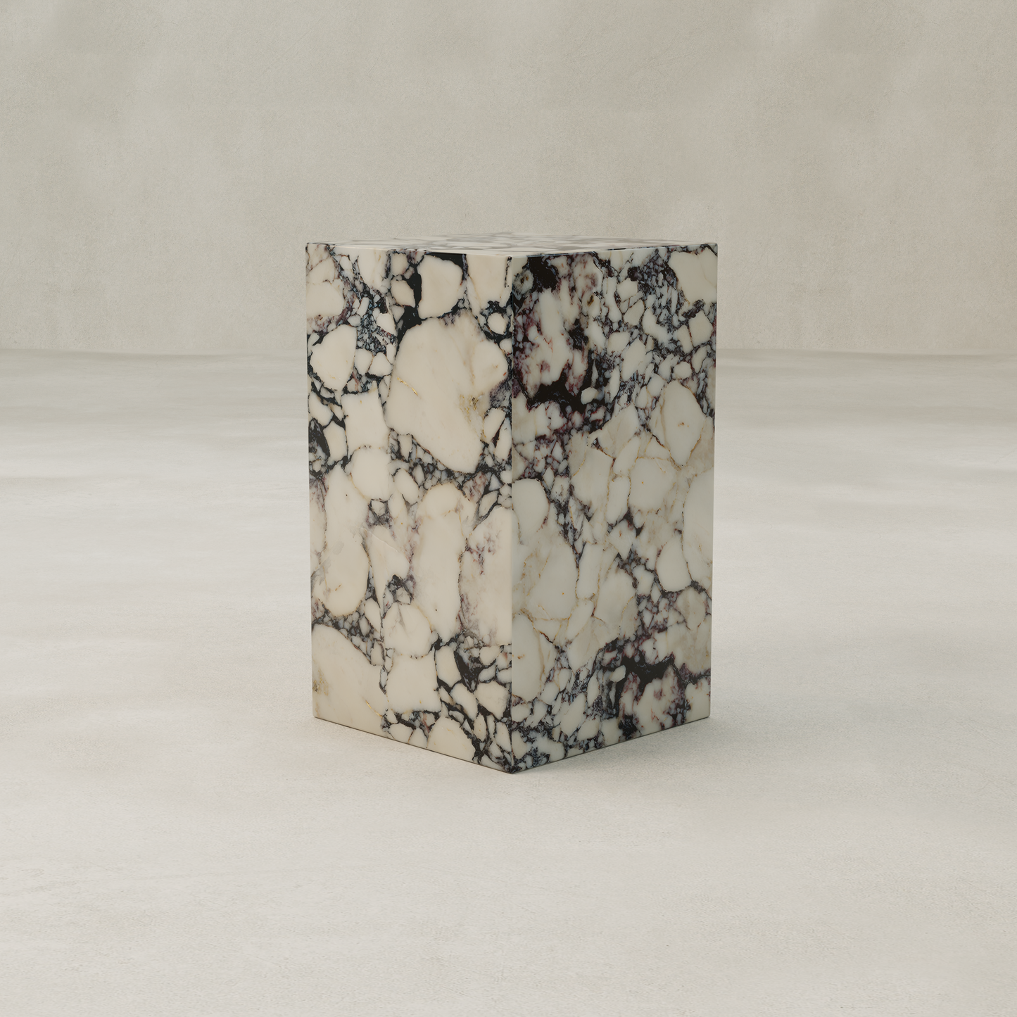 The Azurine Tall Plinth, with its white marble surface and bold dark gray veining, stands on a smooth light beige floor against a matching wall, creating a striking contemporary statement piece.