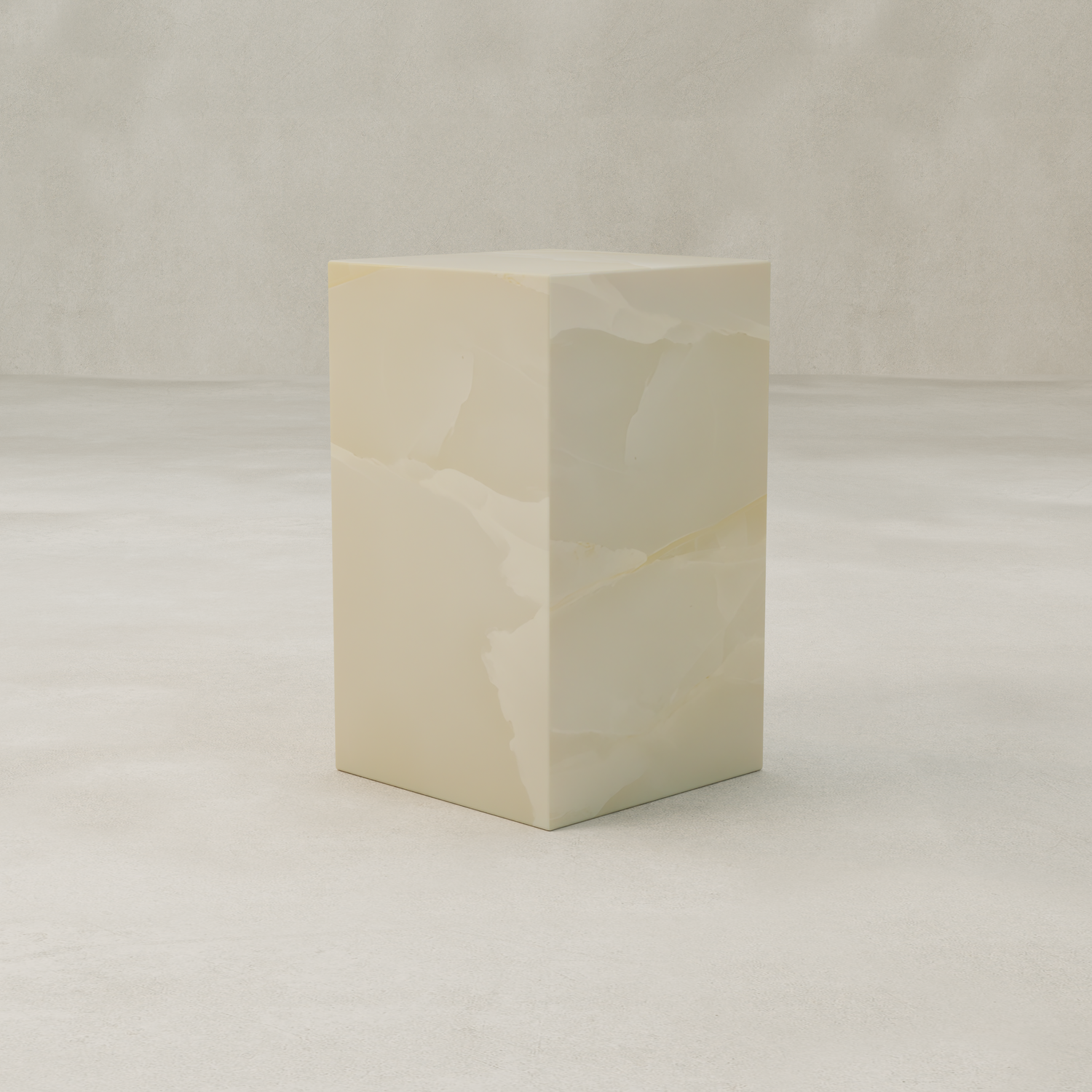 The Lunelle Onyx Plinth - Tall, a rectangular piece in light beige with subtle marbled patterns, stands as a sculptural focal point on a pale textured surface against a neutral background.