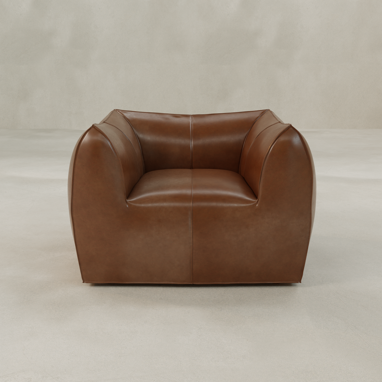 The Bambon Armchair features a modern, boxy design with rounded arms and vintage leather upholstery, offering a deep, cushioned seat for timeless comfort. It stands on a light, textured floor against a neutral, pale backdrop.