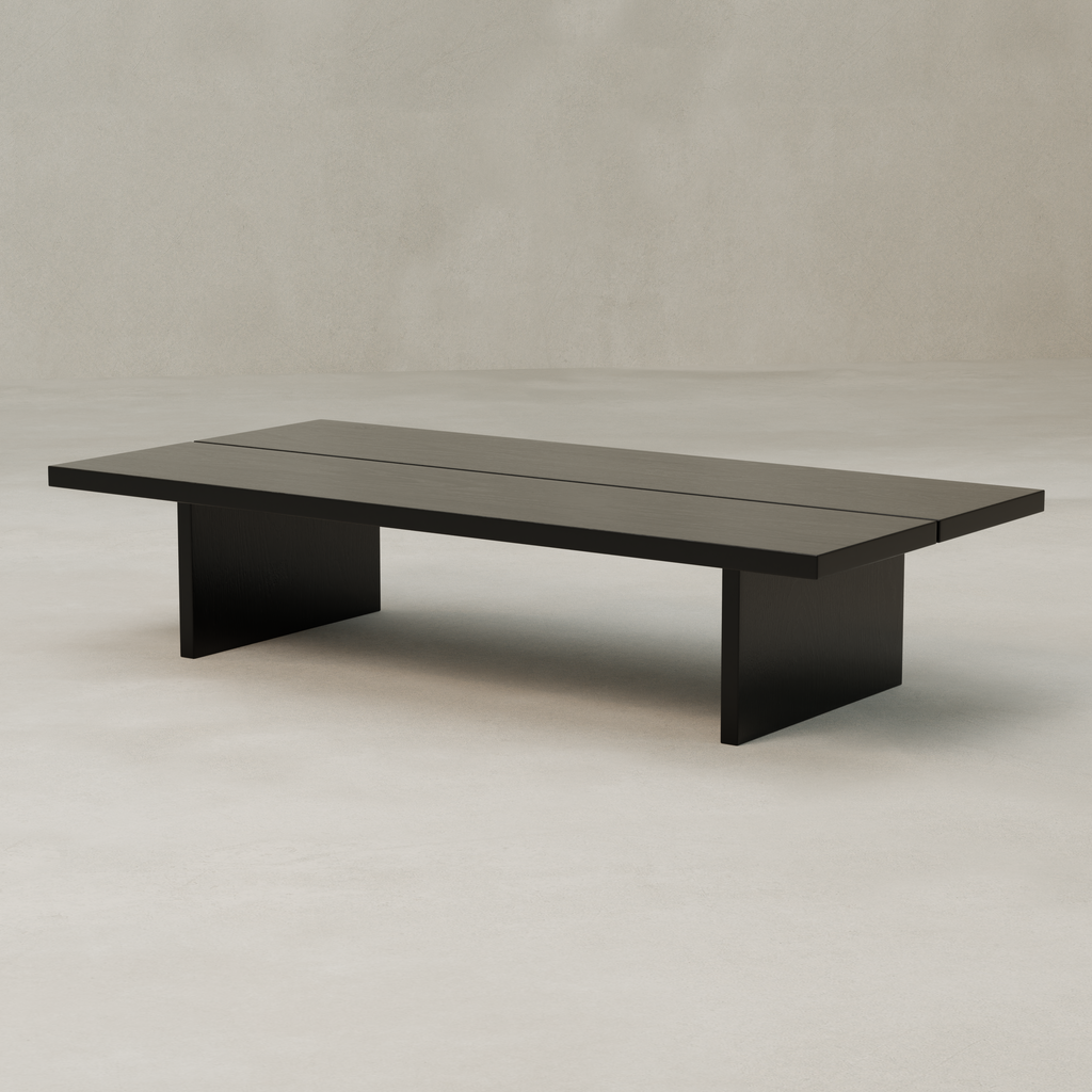 The Bastion Coffee Table is a minimalist, rectangular piece made from solid pine with a flat top and two wide slab legs, set against a neutral background for subtle rustic charm.