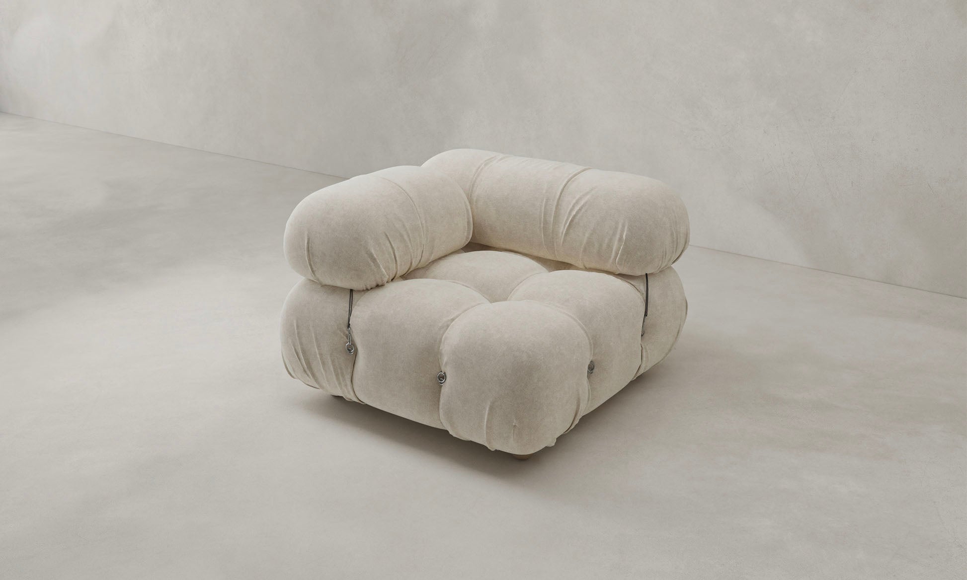 The Belmont Sofa Right Armrest, in plush light beige with soft rounded cushions and exposed metal fasteners, exemplifies modular design against a plain, light background.