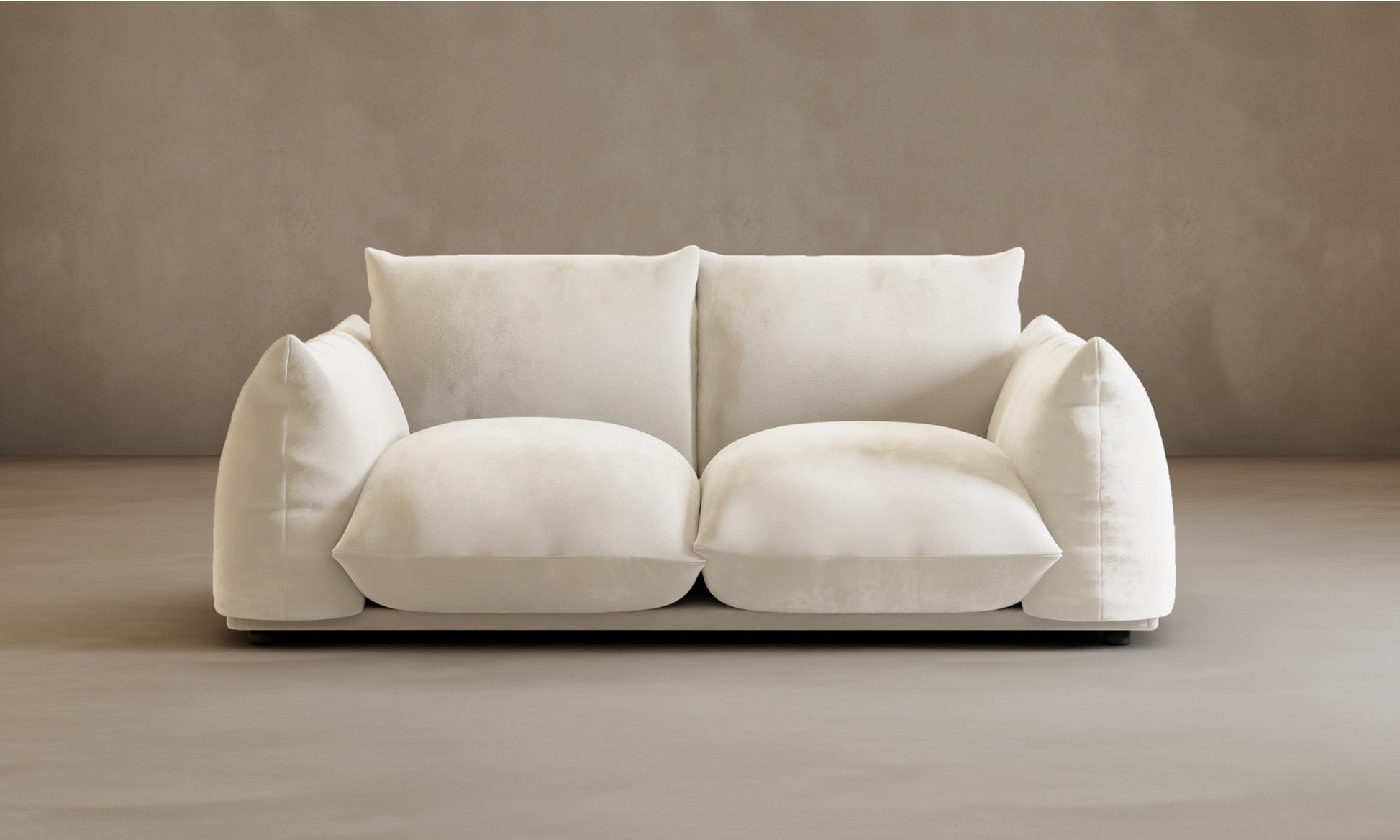 The Calypso Loveseat, a modern 2-seater in dark brown with overstuffed seat and back cushions, stands out against a beige wall and light floor, combining contemporary style with plush comfort.