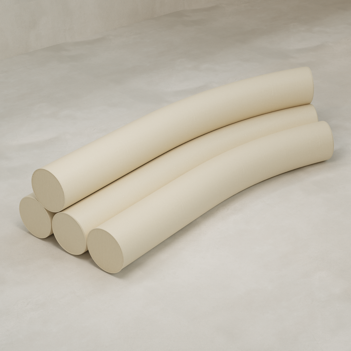 Four large Cylindra Sofas, cream-colored and cylindrical in shape, are arranged in parallel on a light textured surface. Each sofa features a gentle curve and is set against a plain, neutral background.