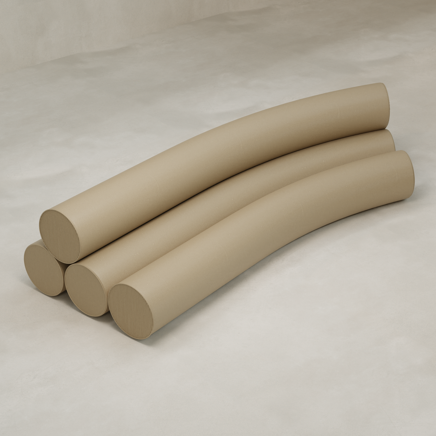 Four large, curved beige Cylindra Sofa pieces are stacked on a light, textured surface, resembling smooth foam tubes and evoking playful neotenic sofa shapes in an abstract arrangement.
