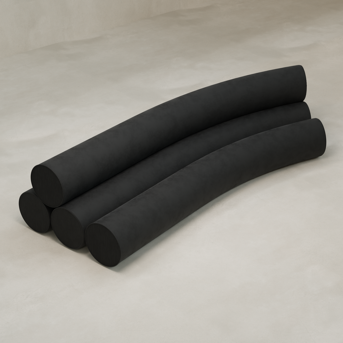 The Cylindra Sofa features four large, black, slightly curved cylinders—three forming the base with one on top—stacked on a light, smooth floor for a modern look.