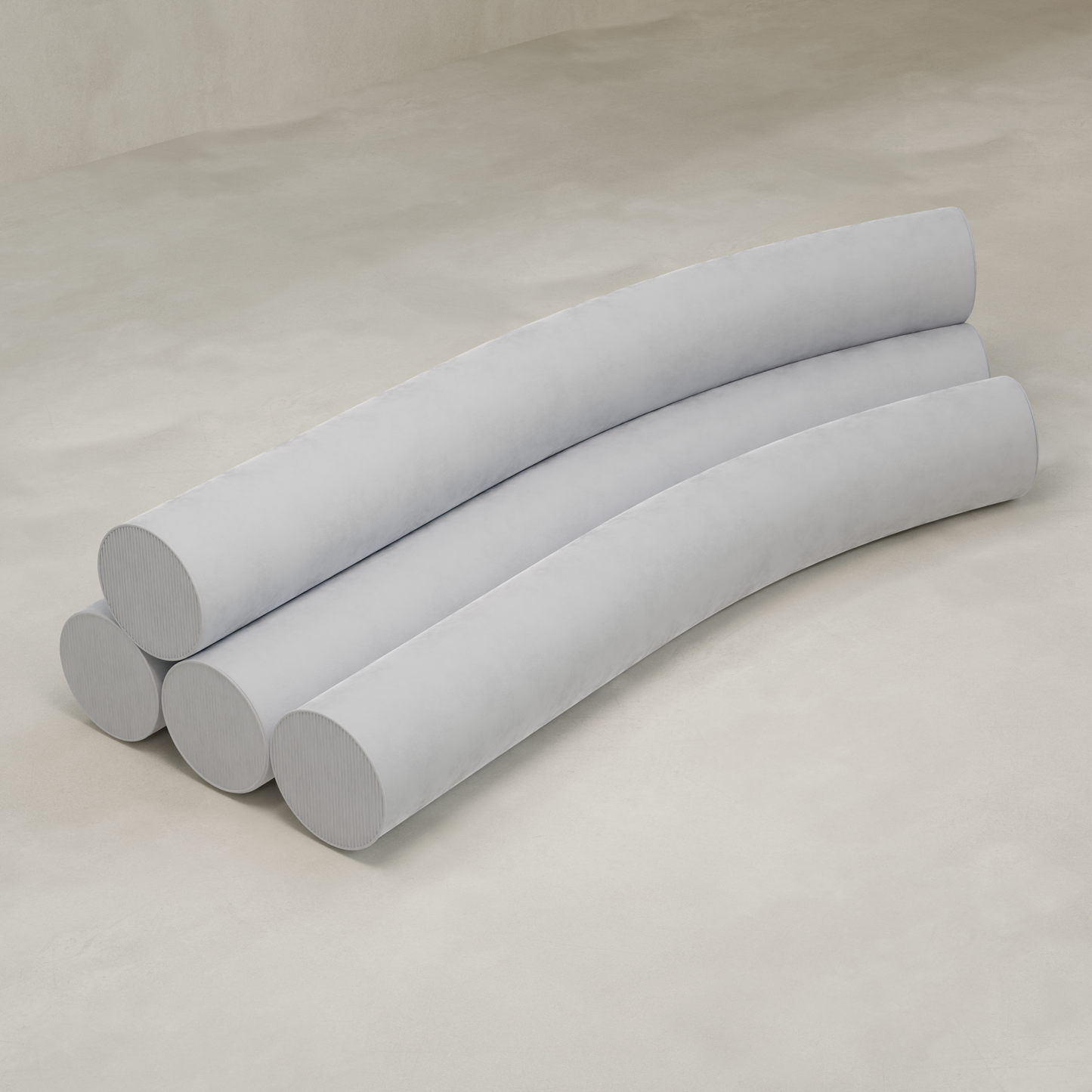 Four long, light gray cylindrical cushions are arranged in parallel, slightly curved lines on a smooth beige surface, evoking the playful silhouette of the Cylindra Sofa.