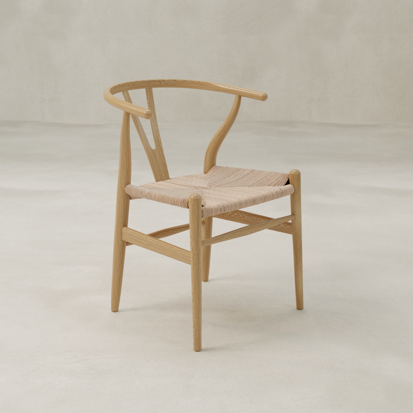 The Elsa Chair, featuring a wooden Y-back, curved backrest, and woven seat, stands out against a light background. Its minimal modern design highlights natural wood grain—ideal as a dining chair next to a farmhouse table.