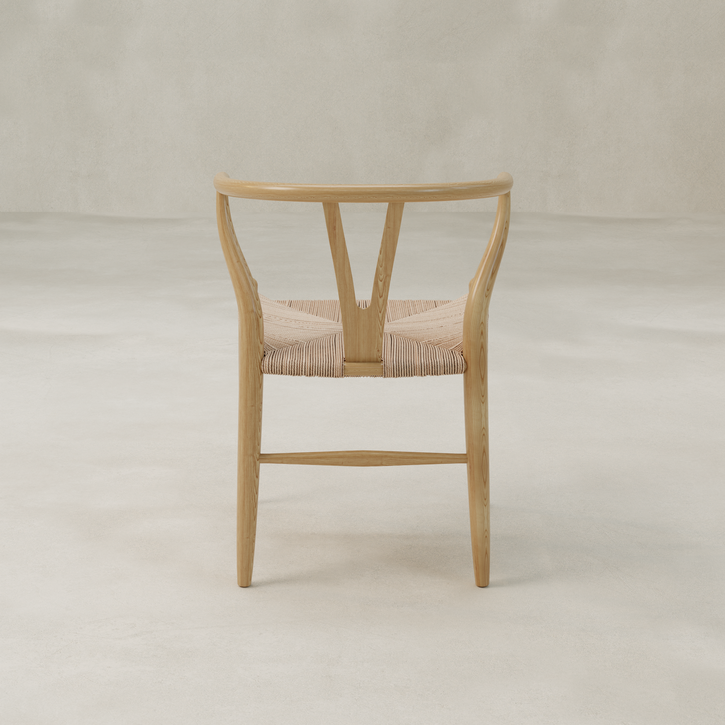 The Elsa Chair features a light wood Y-back design with a curved backrest and woven seat, shown from behind against a plain, light-colored background.
