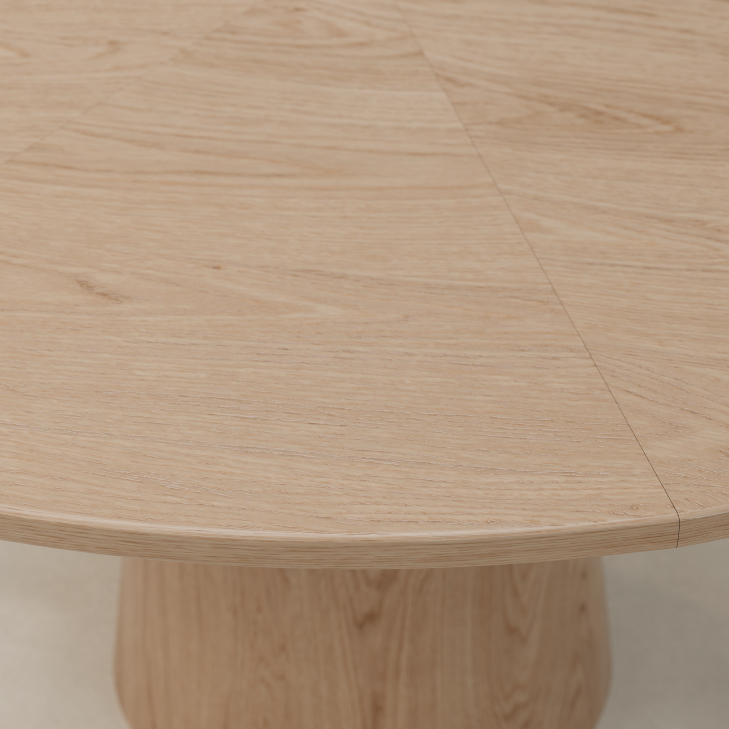 Close-up of the Harlow Dining Table, featuring a round top in light natural wood with distinct grain patterns and segment lines, supported by a wide cylindrical pedestal base.