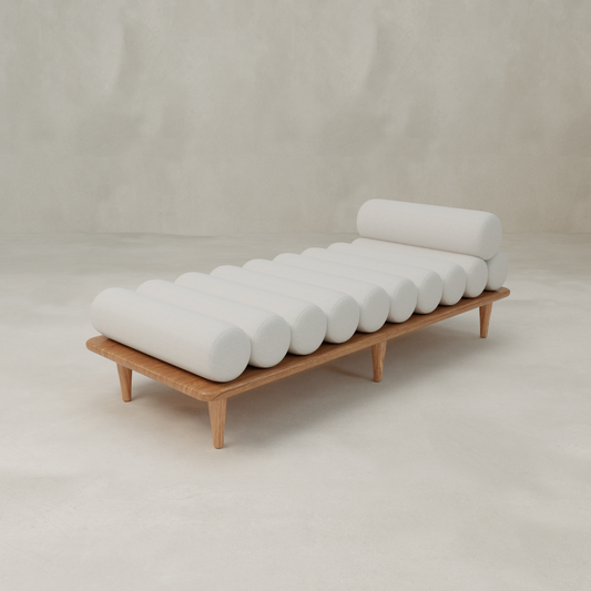 The Kingston Daybed features a modern design with cylindrical white cushions arranged horizontally, showcased against a light, minimalist background.