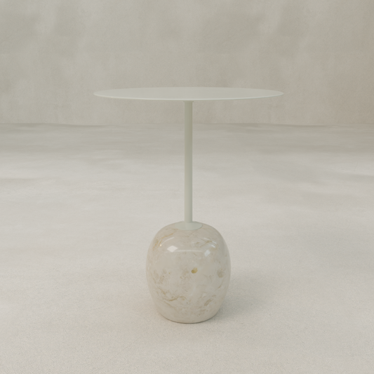 The Le Folie Table Crema Tall is a contemporary round tea table with a slim top and single central stone leg, supported by a marble-like rounded base, displayed against a plain, light-colored background.