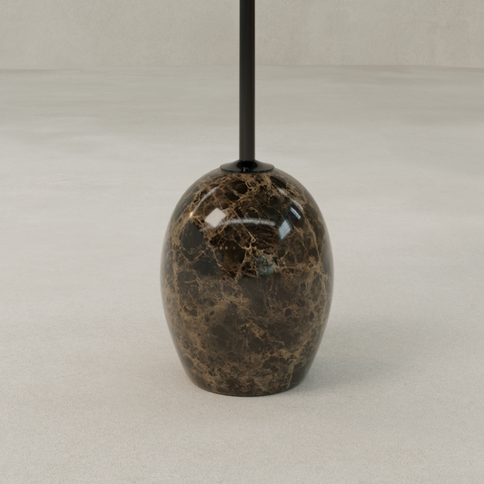 A close-up of the Le Folie Table Noir Grand Antique Tall, featuring a glossy, dark brown marble-patterned base on a smooth, light floor beside a round tea table.