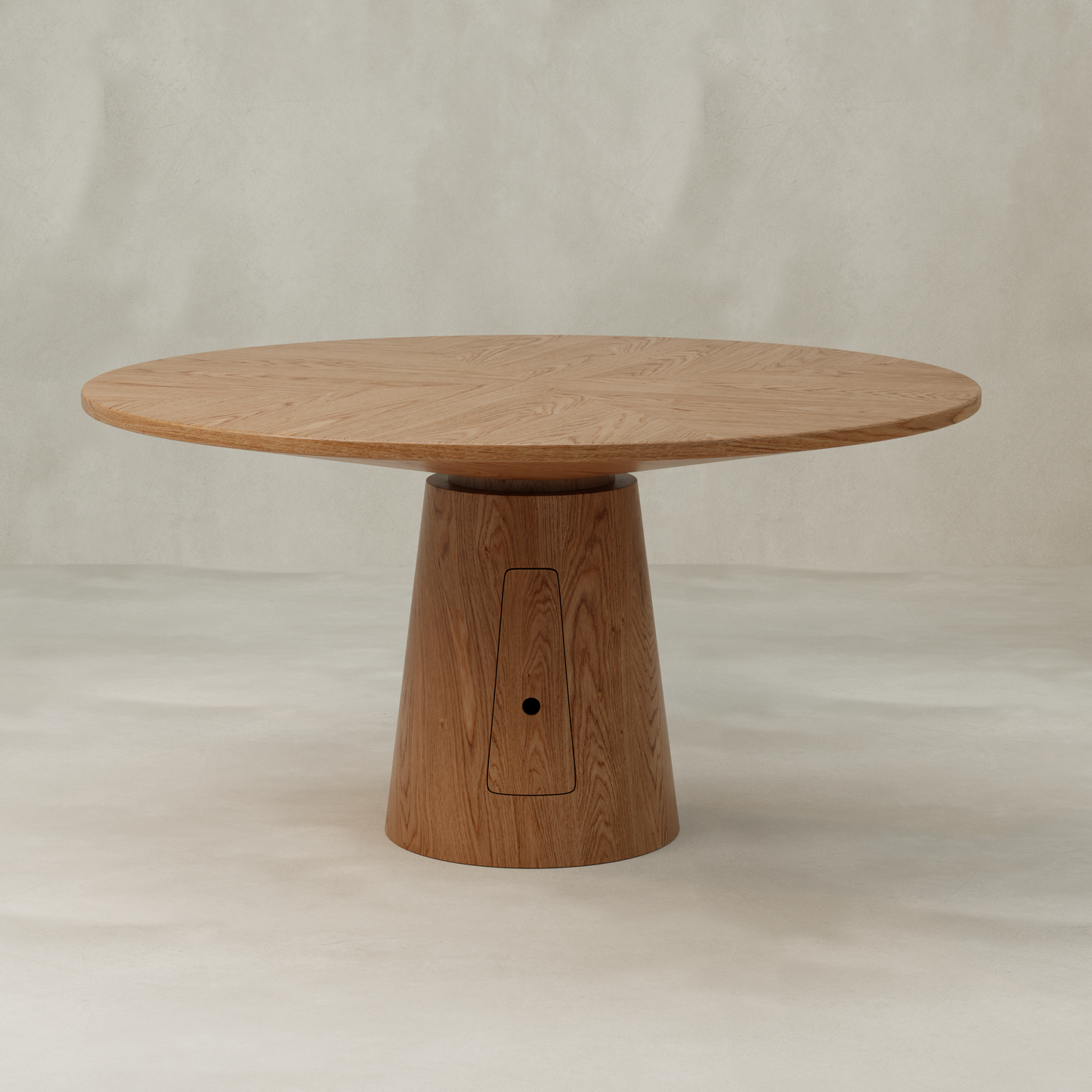 The Nola + Elsa Dining Set features a round wood dining table with a thick, flat top and a wide, tapered cylindrical base, set against a neutral, light-colored background.