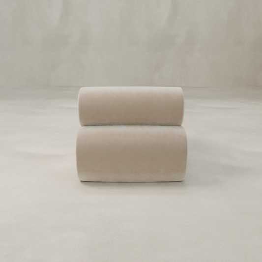 The Nuage Modular Lounge Chair, featuring a modern beige boucle upholstery and rounded, cylindrical design, sits on a light floor against a textured wall—offering a sculptural, minimalist statement for any decor.