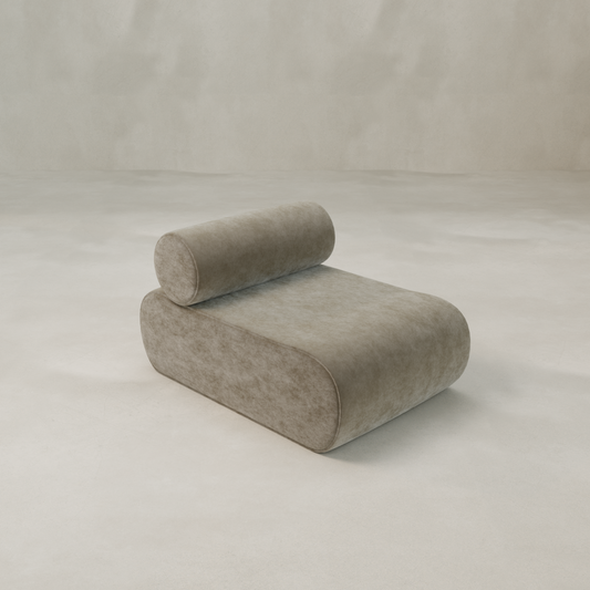 The Nuage Modular Lounge Chair features a modern minimalist design with a cylindrical backrest, rounded edges, and smooth light taupe upholstery, set against a seamless light beige background for a subtle sculptural effect.
