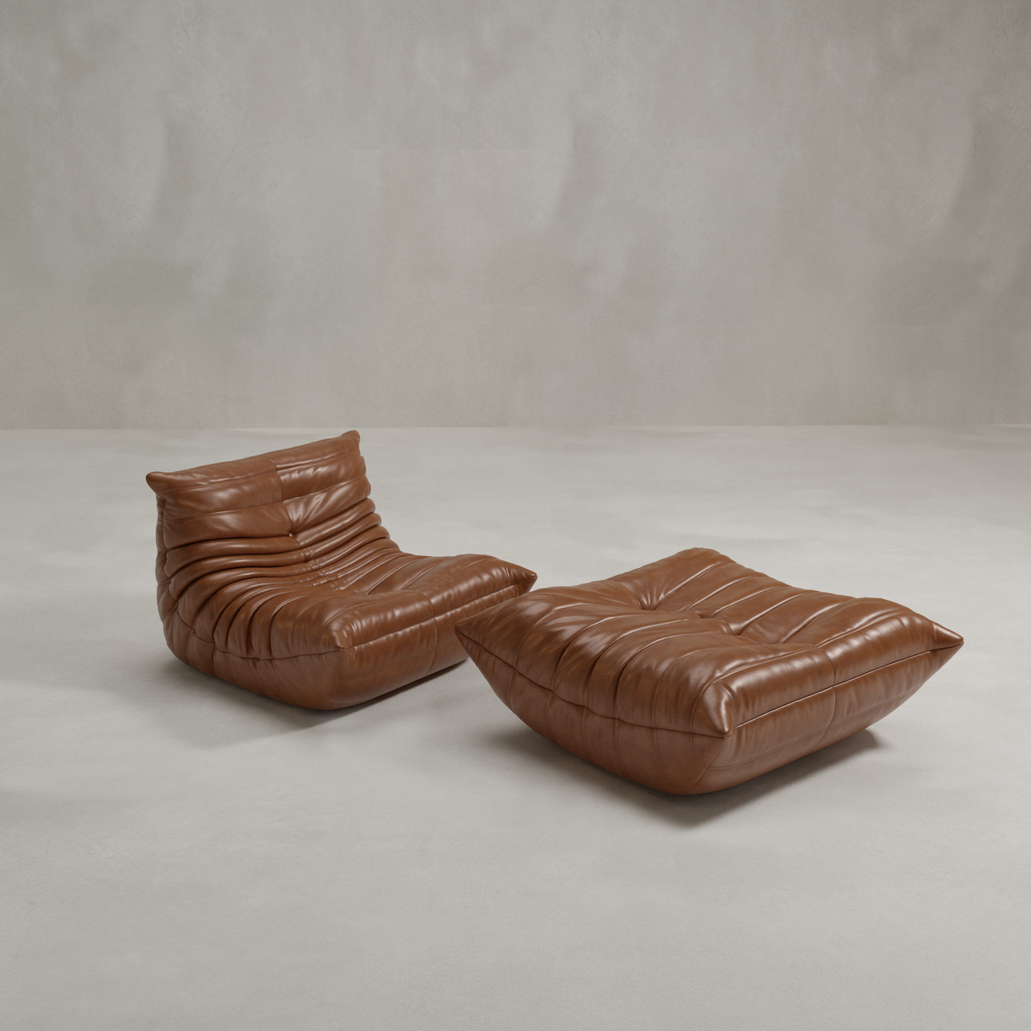 The Rolo Lounge Sofa Chair with Ottoman, featuring deep brown leather and plush cushions, sits on a smooth light gray floor against a textured gray wall.