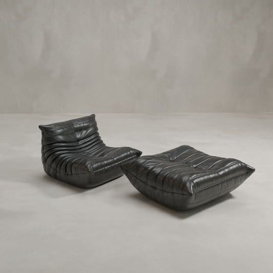The Rolo Lounge Sofa Chair with Ottoman features a modern, 70s-inspired design in black leather with deep horizontal tufting, shown here on a light, minimalist background.
