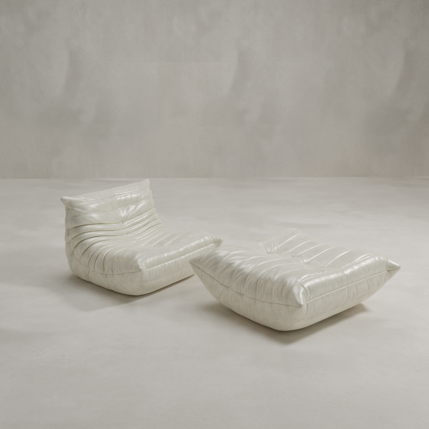 The Rolo Lounge Sofa Chair with Ottoman, inspired by 70s design, features white leather upholstery and a sculpted, cushion-like silhouette. Perfect for modern spaces, it adds mid-century flair against a light gray floor and textured backdrop.