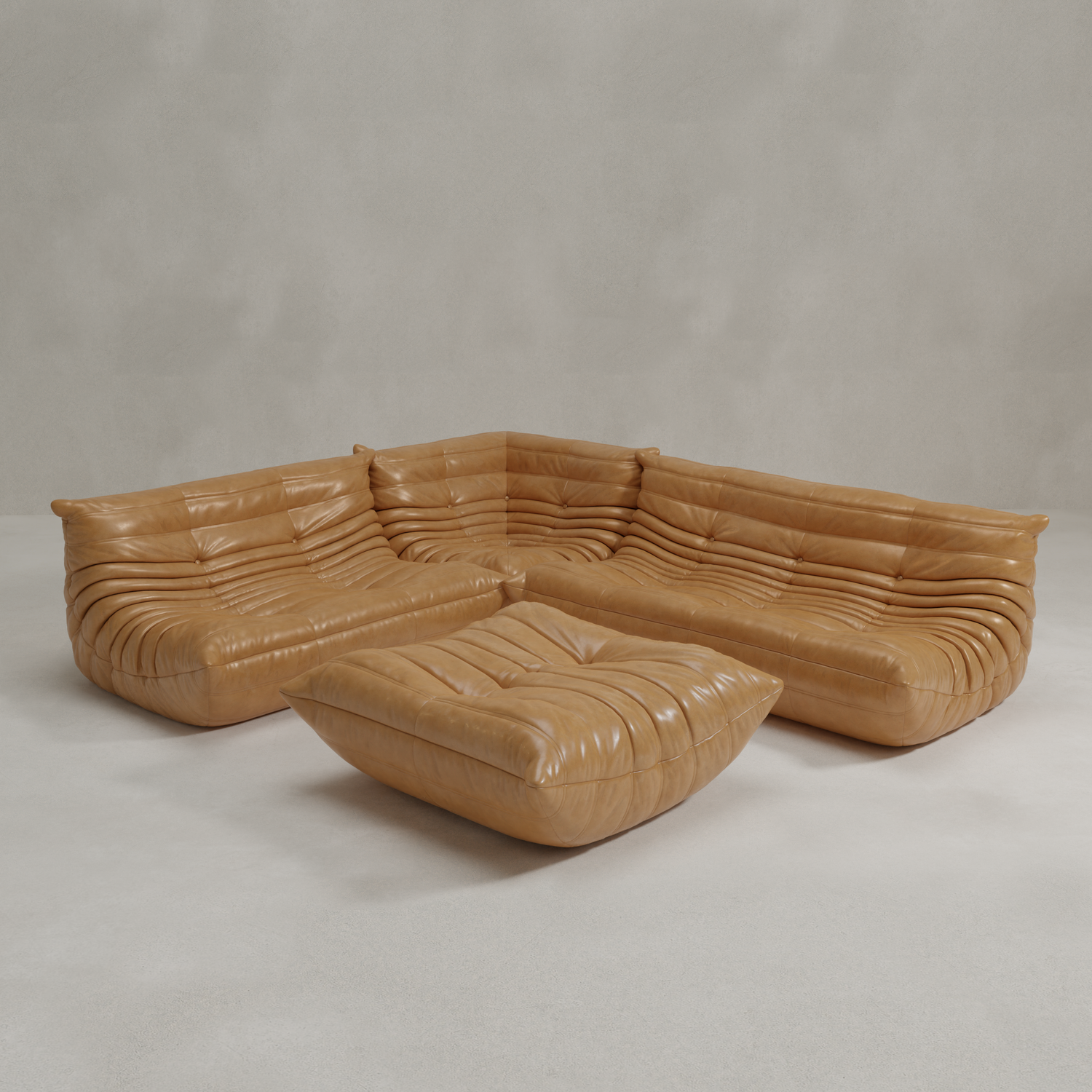 The Rolo Lounge Four Piece Sofa, a tan leather sectional with deep plush cushions and matching ottoman, sits against a plain light gray background. It features a modern low-profile design with horizontal tufting and mid-century style touches.