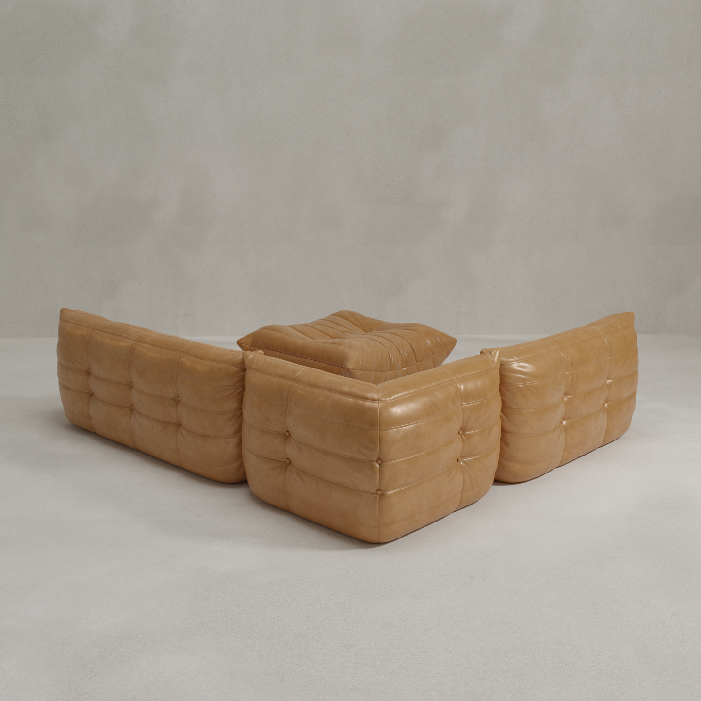 The Rolo Lounge Four Piece Sofa features light brown, tufted leather modular sections arranged in a U-shape on a light grey floor, set against a neutral background with subtle mid-century design influences.