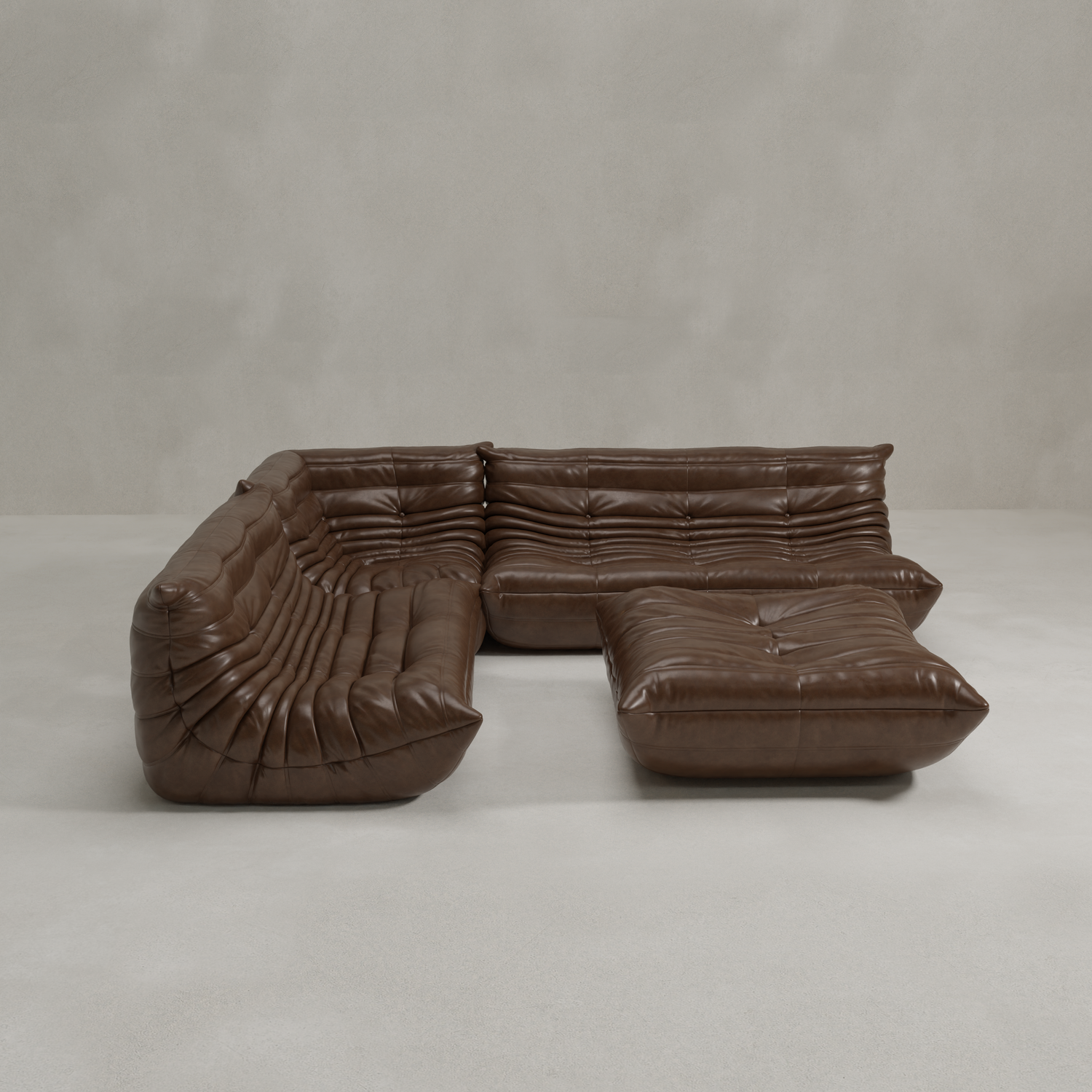 The Rolo Lounge Four Piece Sofa is a modern, modular brown leather sectional with deep cushions and tufted details in a mid-century L-shape, set on a light grey floor against a plain, light grey wall.