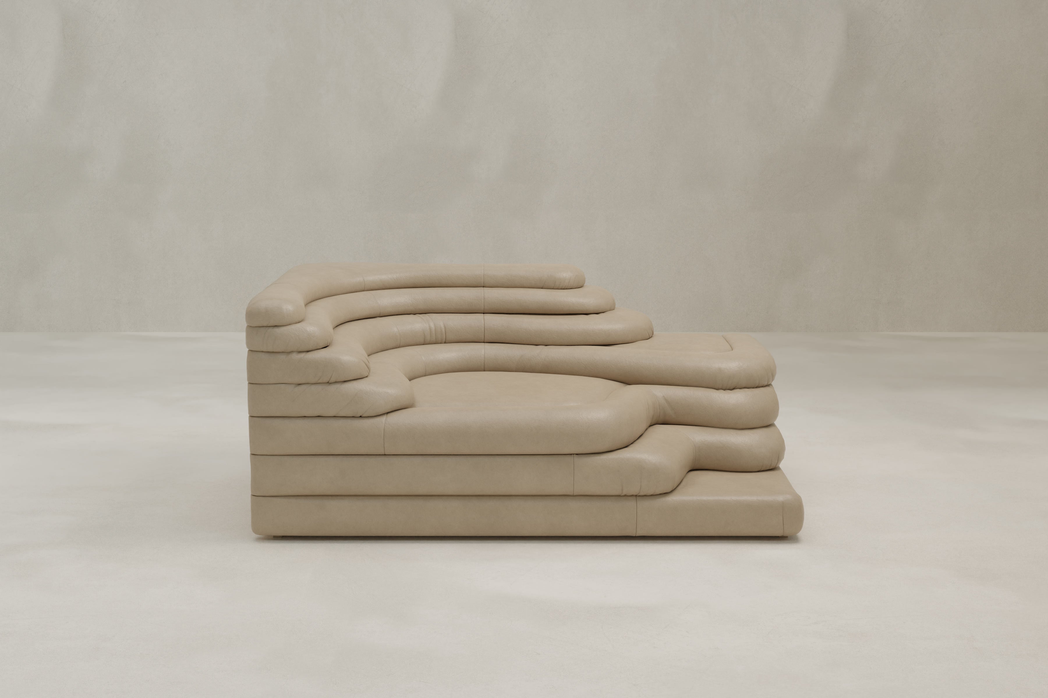 The Cascata Sofa Right Arm is a modern, sculptural beige sofa with layered, rounded cushions and soft, organic curves, shown against a plain light gray background. Its luxurious design resembles stacked, padded forms.