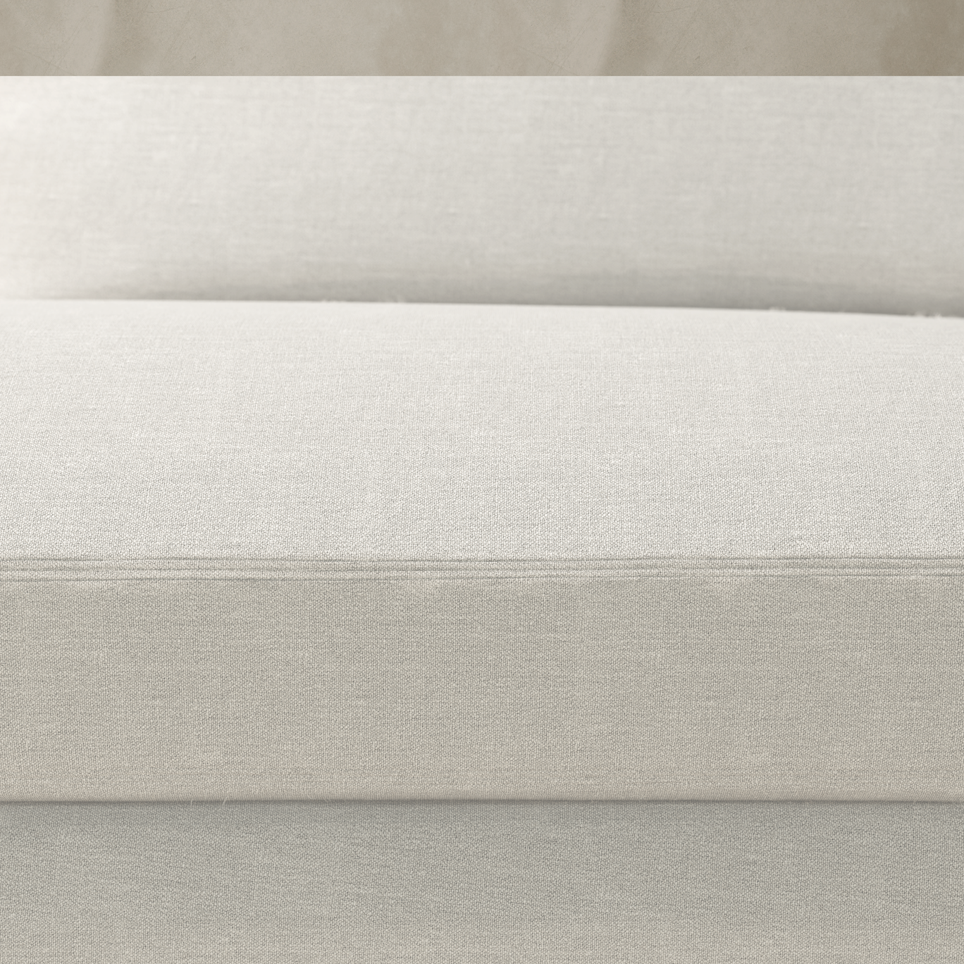 Close-up of the Woolsey Sofa in light beige fabric, featuring textured seat and back cushions. The background displays a matching neutral palette, creating a cohesive look.