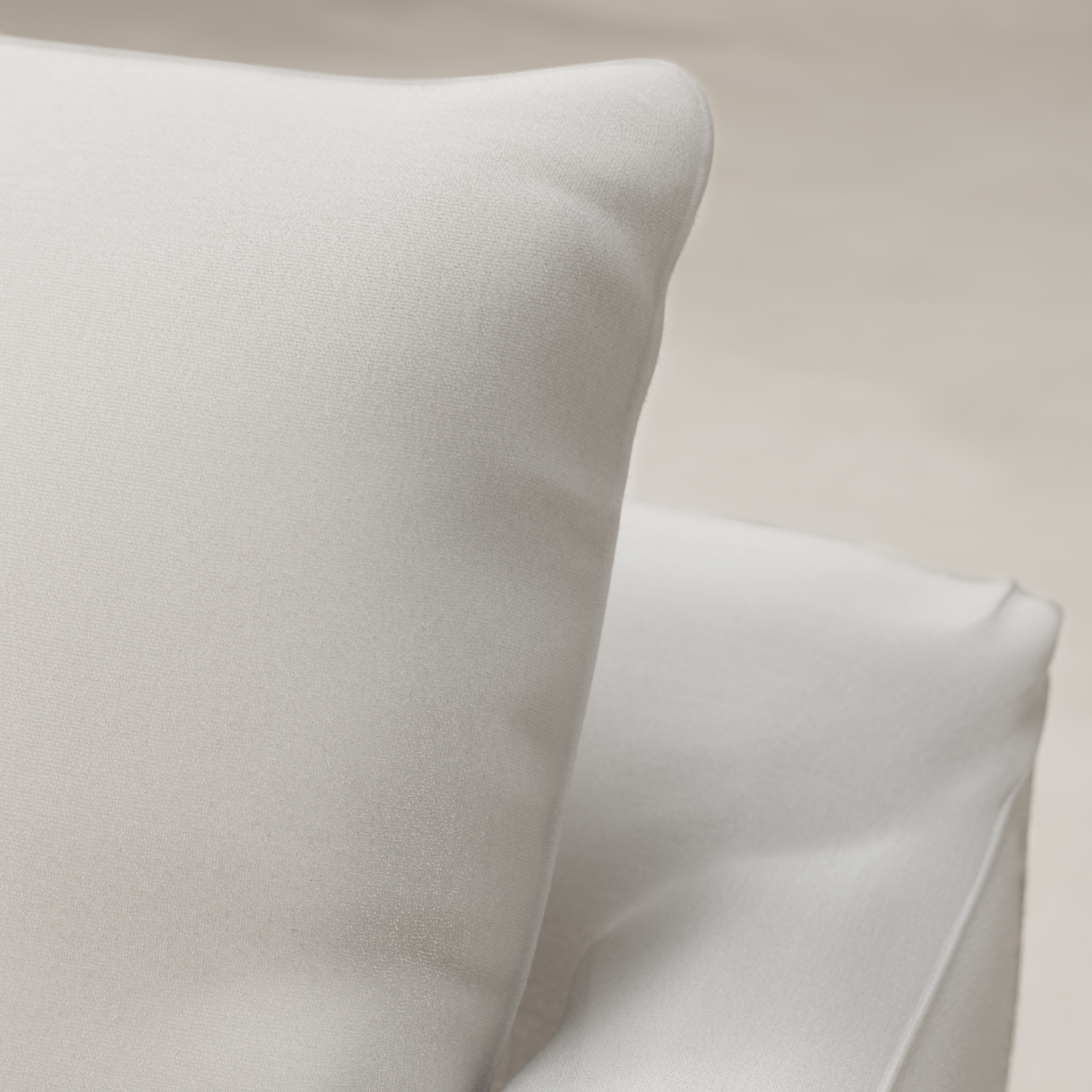 Close-up of two soft white fabric cushions with a smooth texture, placed on the Woolsey Sofa in natural-toned fabric against a neutral background.