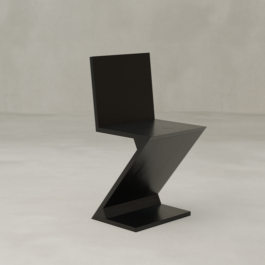 The Z Chair features a sleek black finish and minimalist zigzag design, elegantly placed on a light surface with a neutral backdrop—ideal for modern interiors.