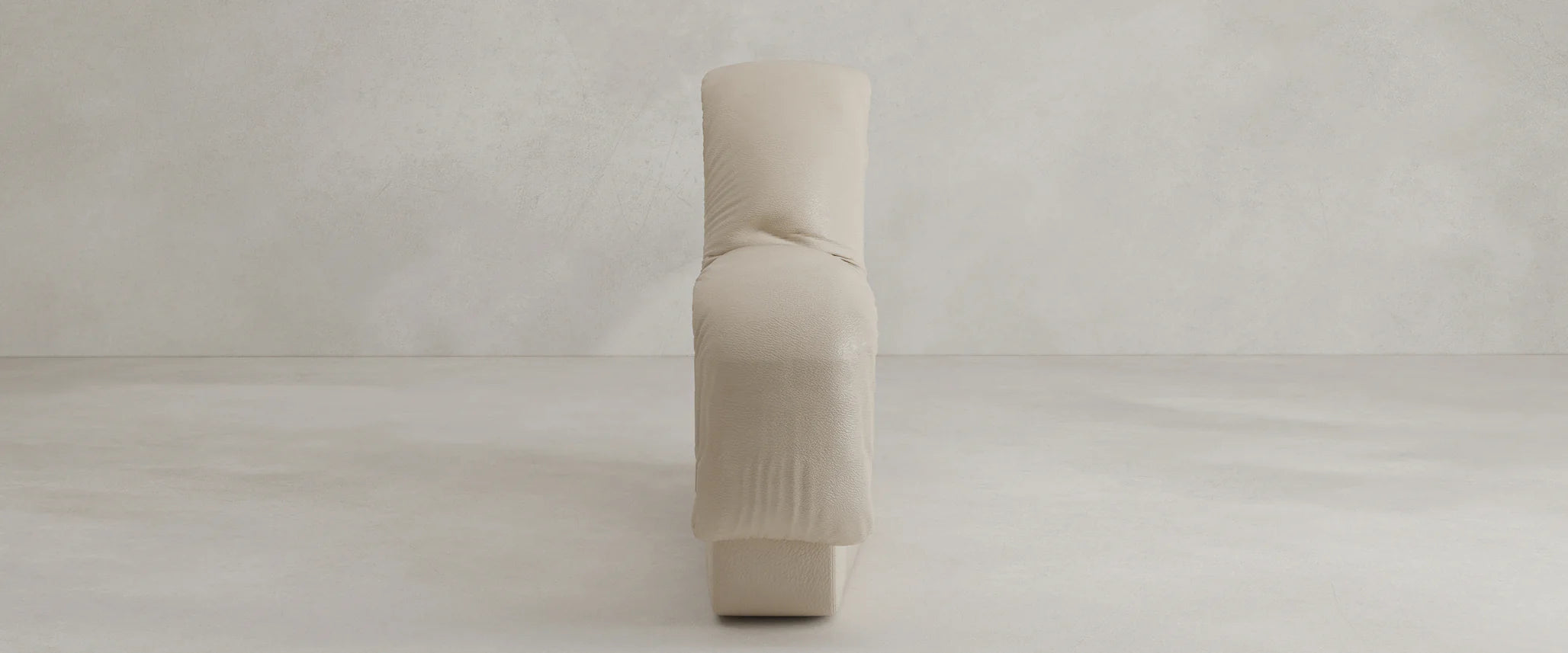 The Serpenti Sofa Seat Module is a modern, minimalist beige armchair with soft, rounded cushions, shown from the side against a light textured wall and floor. Its modular design lets you rearrange individual seat elements for flexible seating.