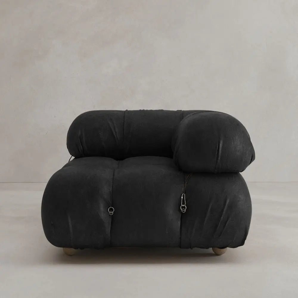The Belmont Sofa Left Armrest, a modern black piece with marshmallow-like curves and visible metal fasteners, is displayed against a light, minimalist background.
