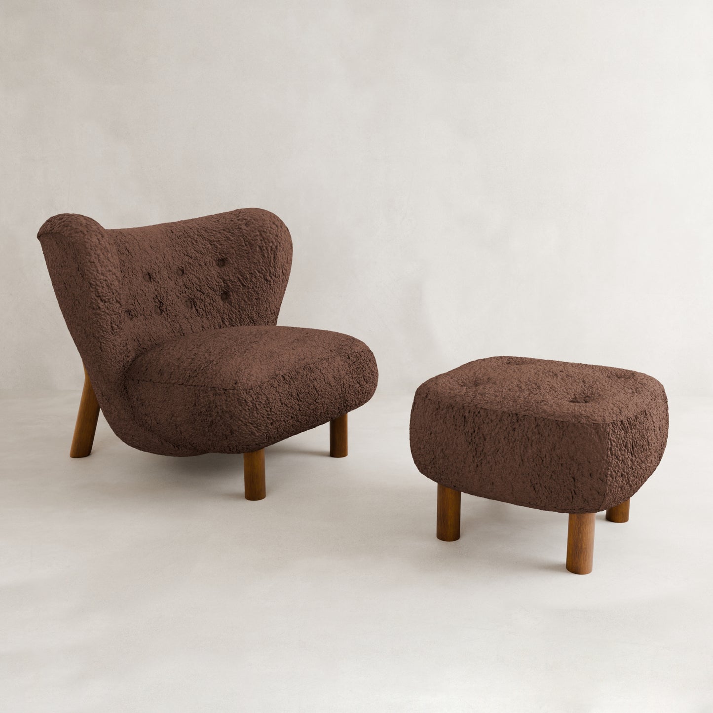 The Highgate Chair With Ottoman features a cozy, modern curved design with wooden legs and vegan shearling upholstery, set against a light backdrop—a true contemporary statement piece.