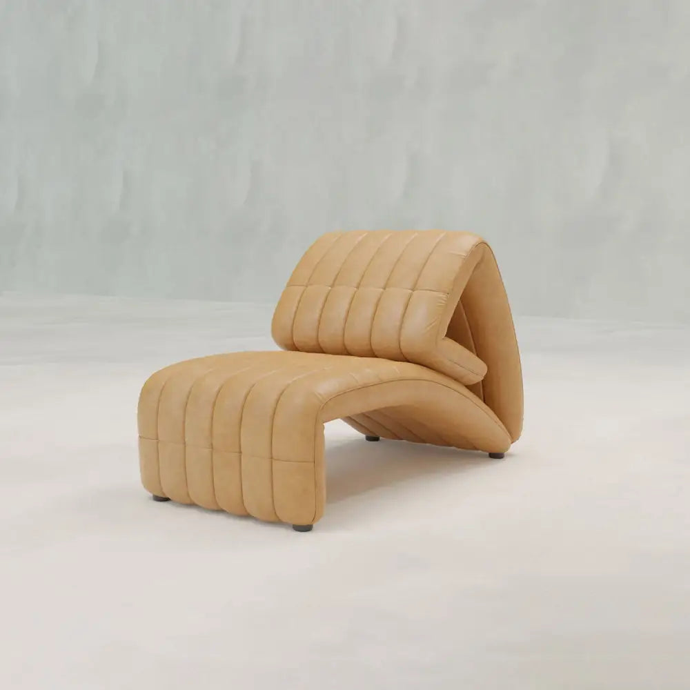 The Hillier Chair features premium vintage leather upholstery, a sculptural curved silhouette with vertical stitching, subtle reclining functionality, and is showcased on a light minimal background.