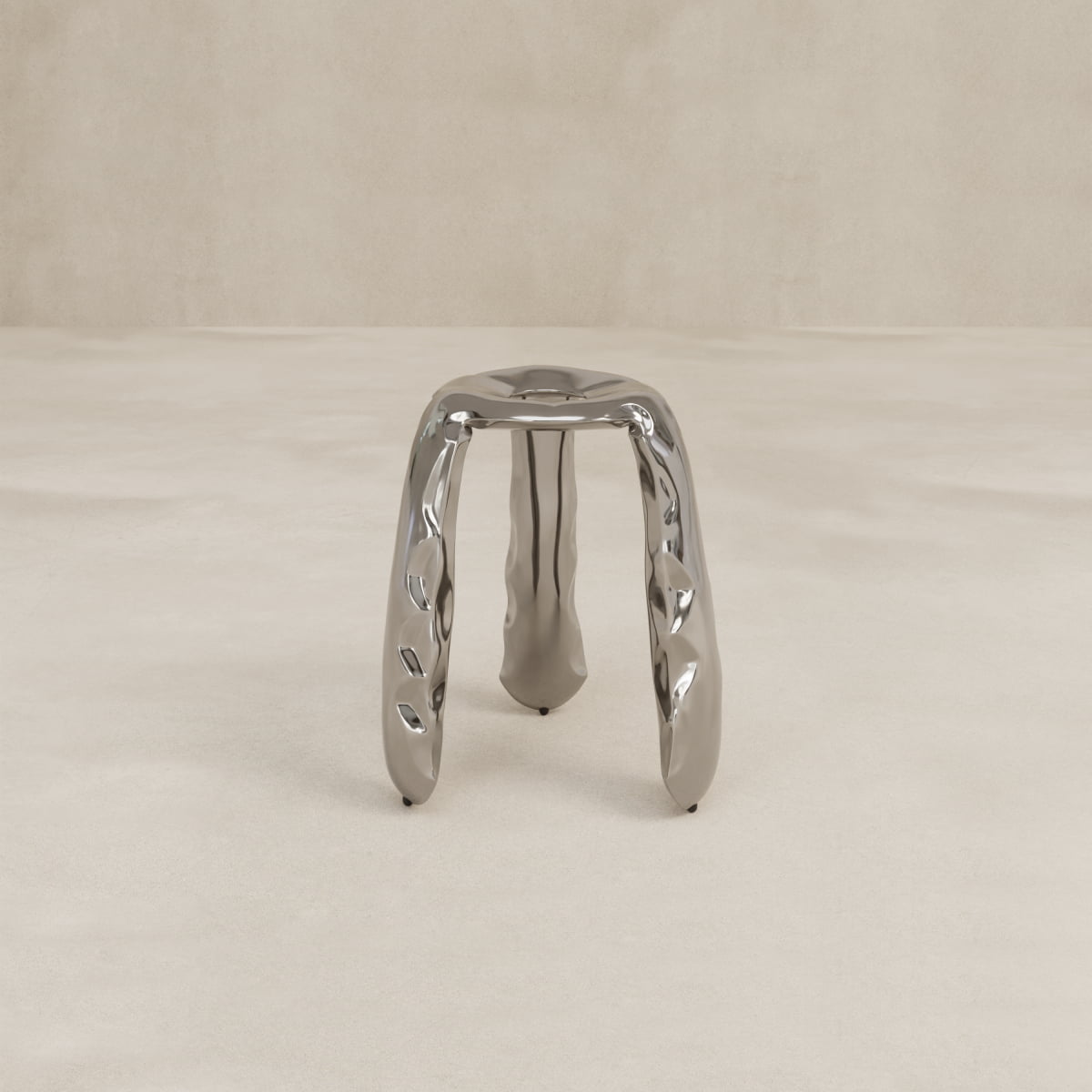 The Araknid Stool Large Rental, featuring three thick sculptural legs and sturdy metallic construction, stands on a light, textured surface against a plain beige background.