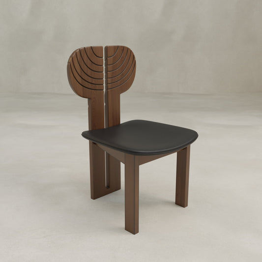 The Arnaud Dining Chair features a wooden frame, black seat, and curved backrest with carved arch patterns, adding a modern touch to dining spaces.
