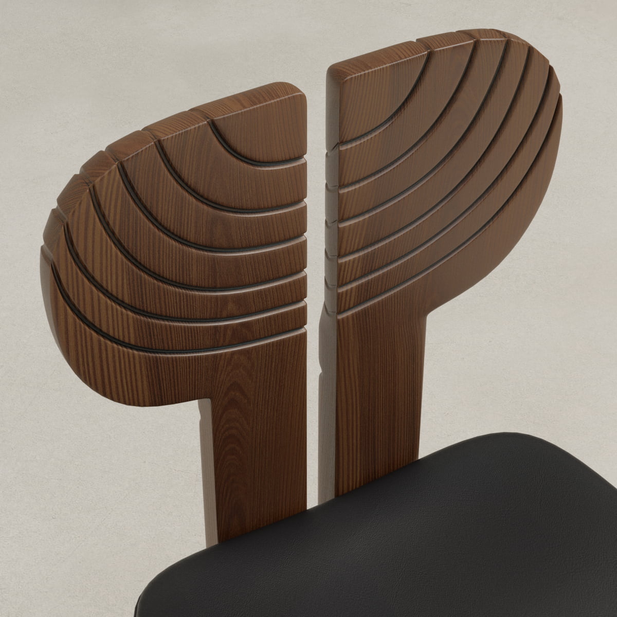 A close-up of the Arnaud Dining Chair’s wooden backrest shows two symmetrical, fan-shaped segments with carved curves. The black upholstered seat introduces a modern touch, ideal for enhancing any dining area with a neutral backdrop.